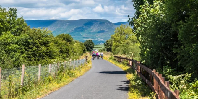 Cycling the Waterford Greenway with scenic mountains in background, Irelands Ancient East Ireland