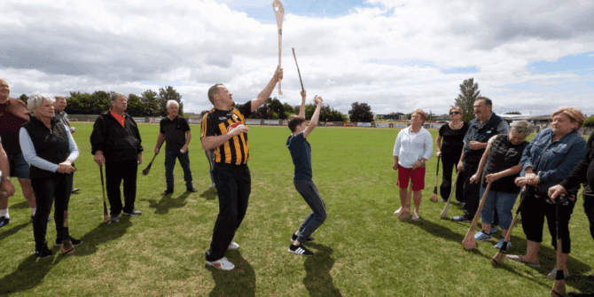 Guide showing group how to play hurling - ANCIENT EAST